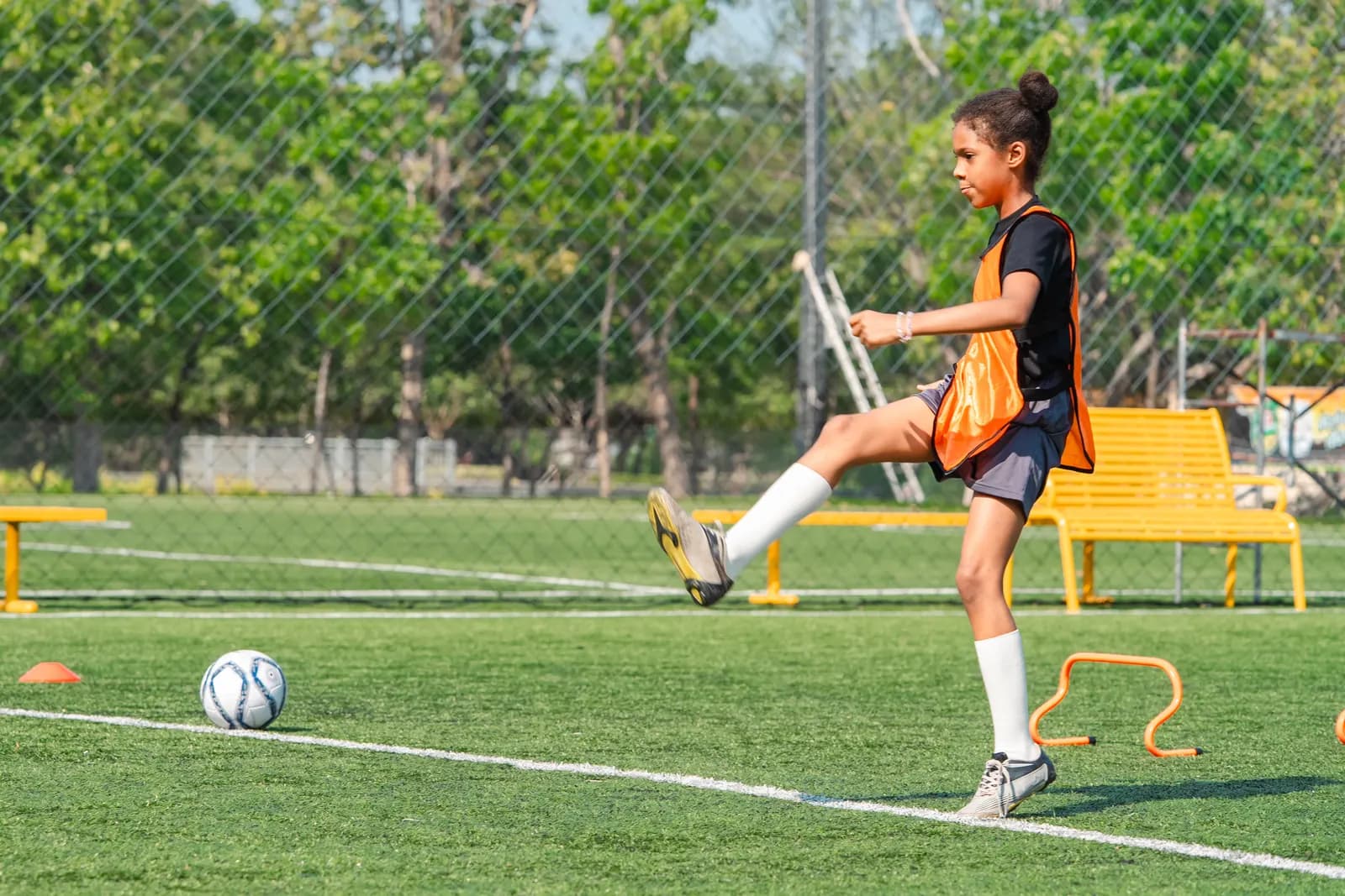 Junge Spielerin beim Training mit Ball auf dem Platz